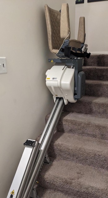 Up stairlift by Harmar shown parked on stairs.