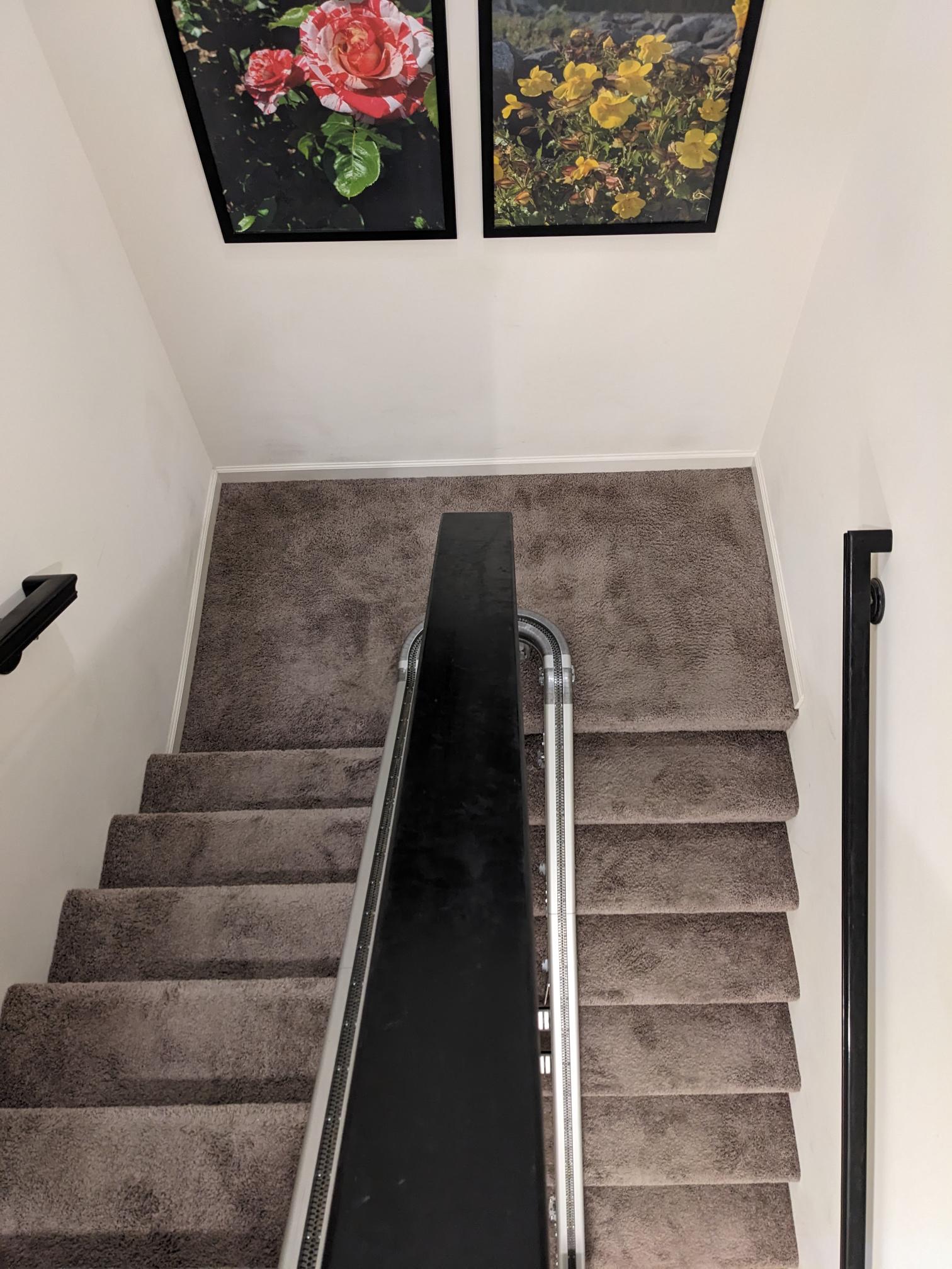Up Stairlift curved track is shown on a split staircase in customer's home.